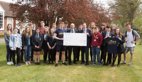 Lion Steve Sidaway presents the Peru students at Malton School with a cheque and their own digital app to record their adventures this summer