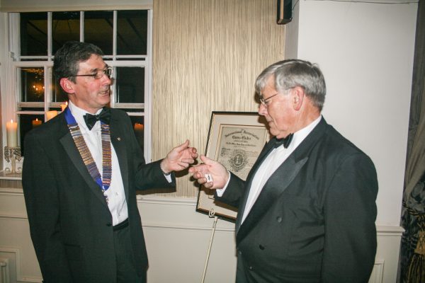 With the Club's Charter presented in 1964 in the background, President Ian presents Lion Brian Maud with his membership key that recognises Brian's sponsorship of new members over the last 12 months