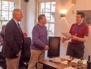 President Lion Ian welcomes Lion Russ as his sponsor - Bill Thompson - looks on